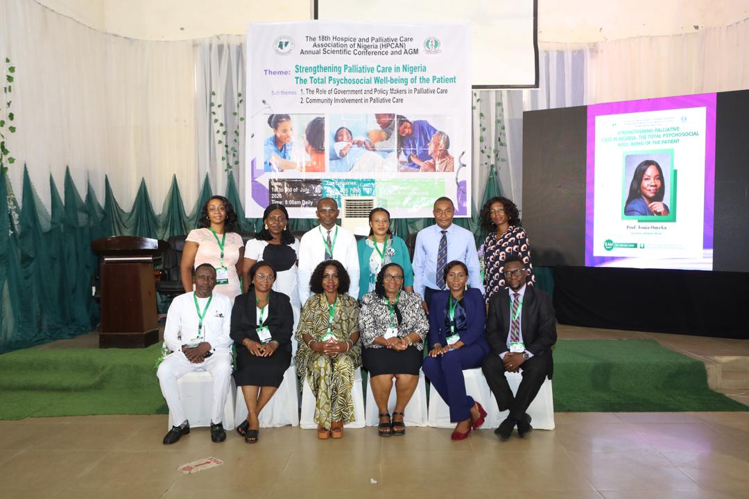 Panel of officials seated on stage in front of the conference banner