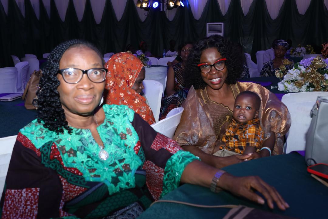 Two guests seated together, one holding a baby